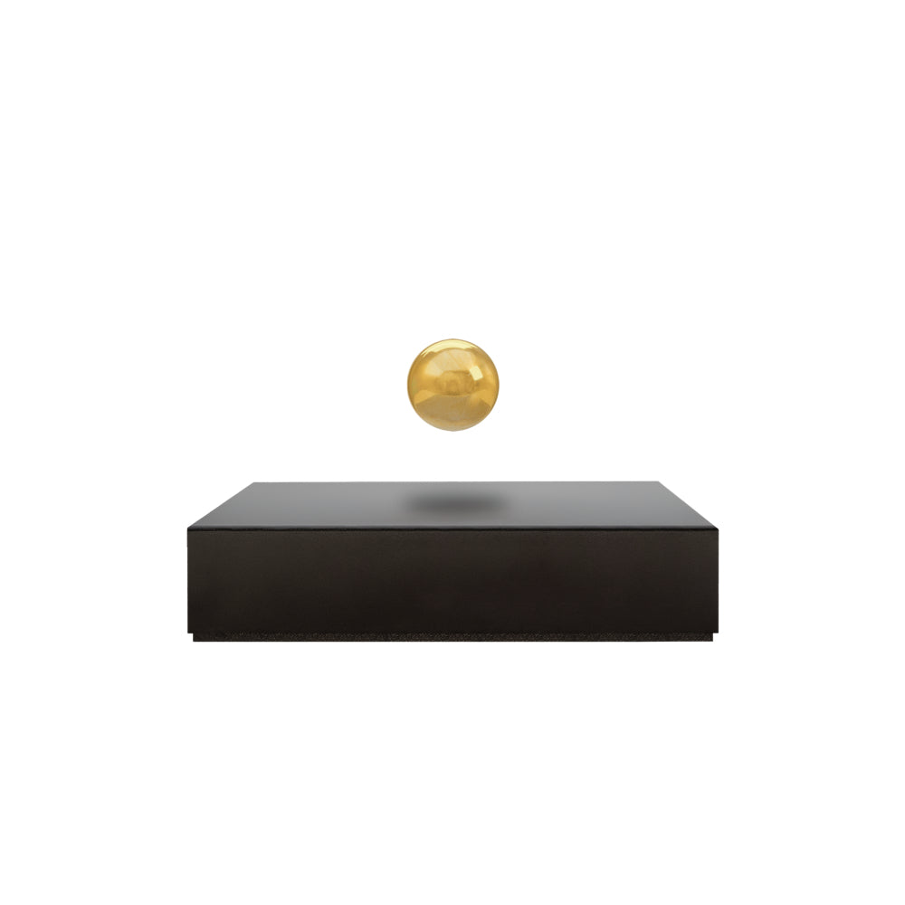 Levitating sphere Buda Ball by Flyte, gold sphere, black base, product photo on a white background