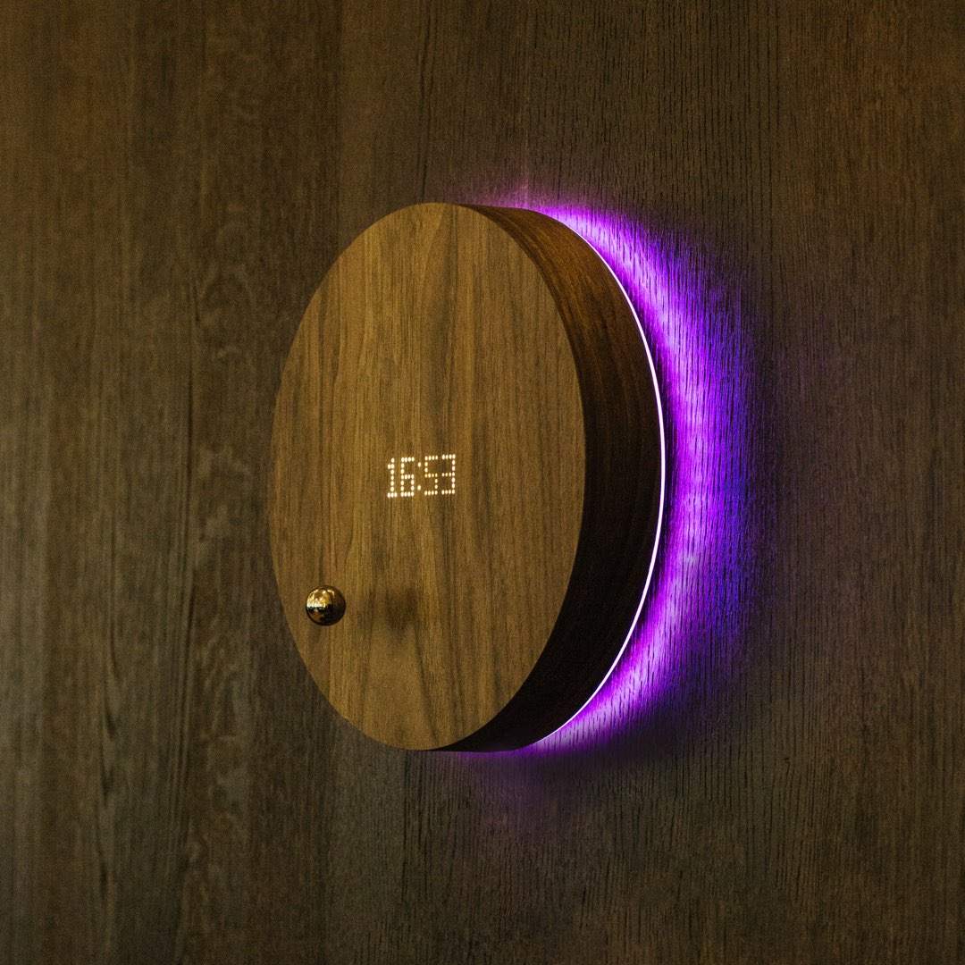 levitating clock on a wooden wall with violet backlight