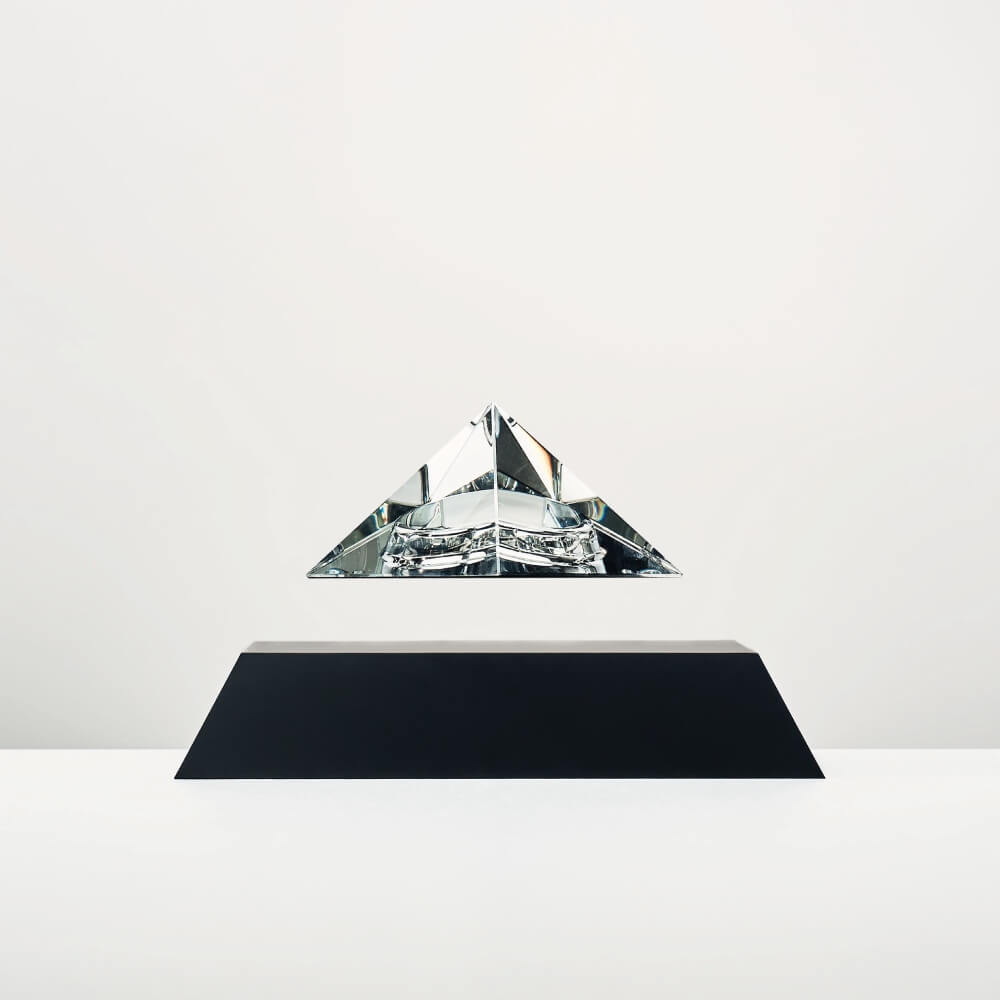 Levitating pyramid Py by Flyte, clear crystal top, black base, product photo on a white background