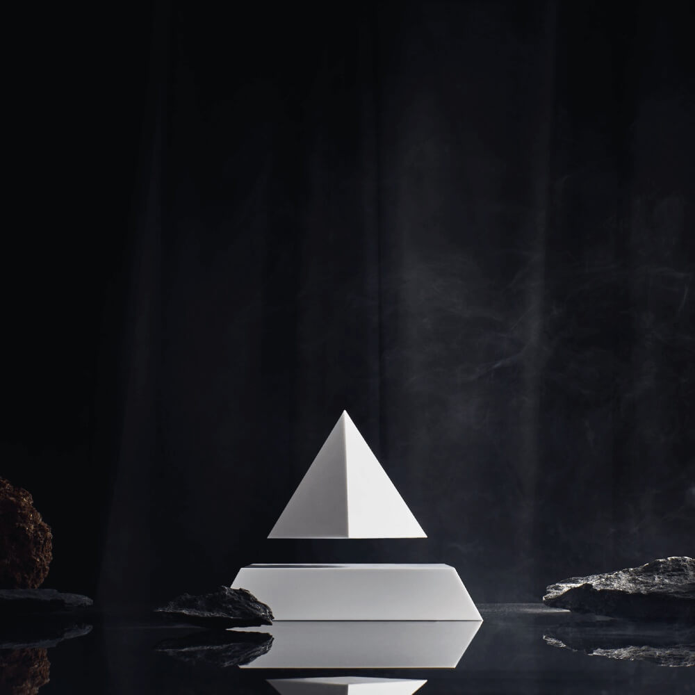 Levitating pyramid Py by Flyte, white top on a white base in a dark, mysterious settimg