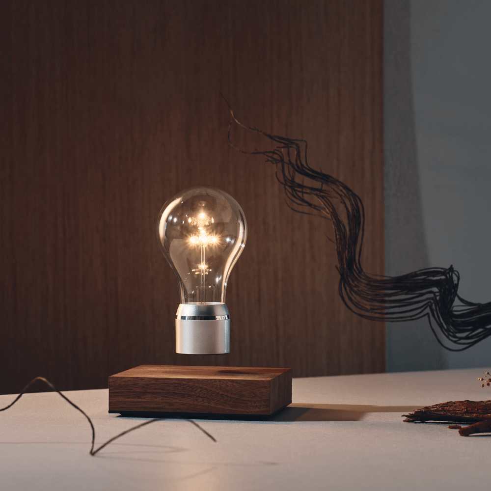 Levitating light bulb Light by Flyte, walnut base and chrome cap bulb in a dark interior setting