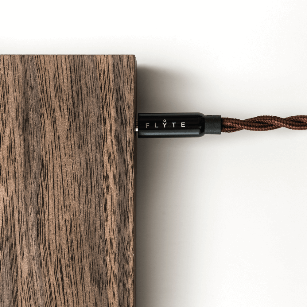 Close up of a Flyte logo detail on cable plugged in a walnut magnetic base