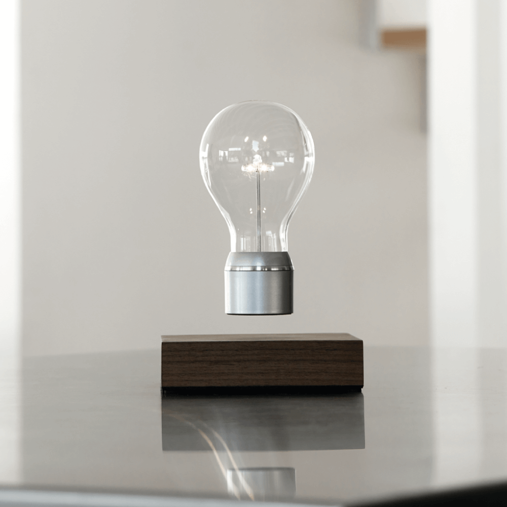 Levitating light bulb Light by Flyte, walnut base, chrome cap bulb in a light interior setting