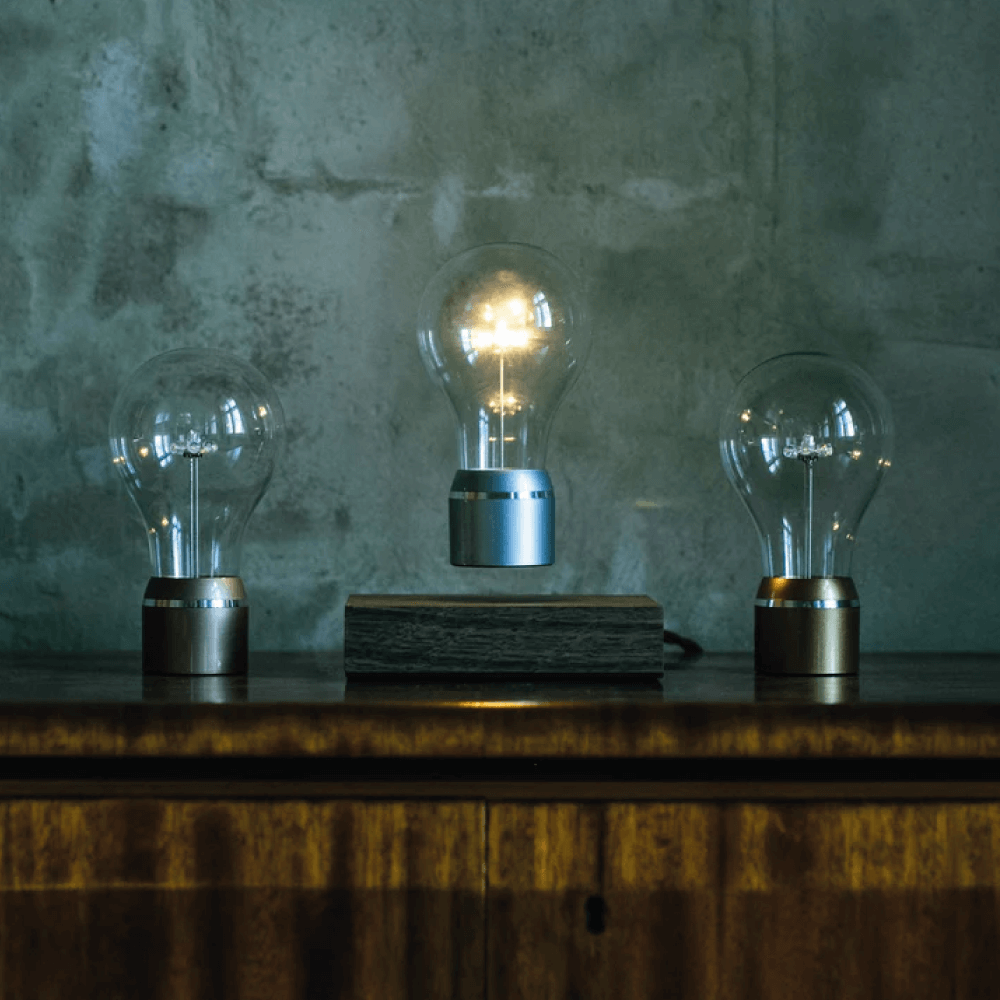 Levitating light bulb Light by Flyte levitating on a walnut base with copper, gold and chrome single bulbs