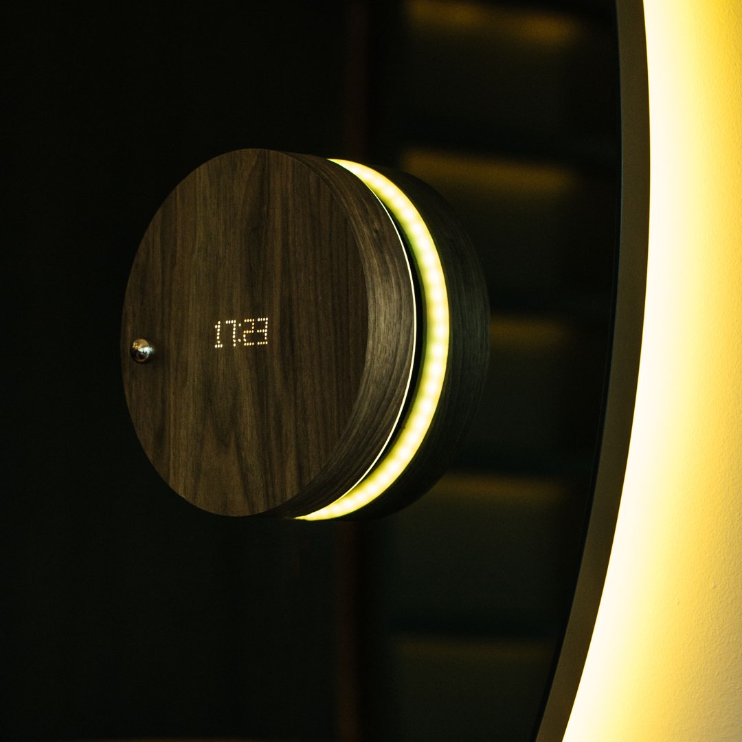 Levitating clock on a mirror with frond led on and backlight in yellow
