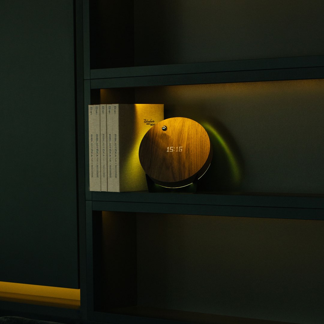levitating clock on a shelf with books and yellow backlight